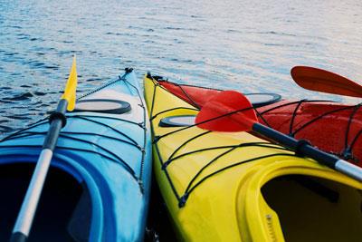 three colorful kayaks next to each other in the water